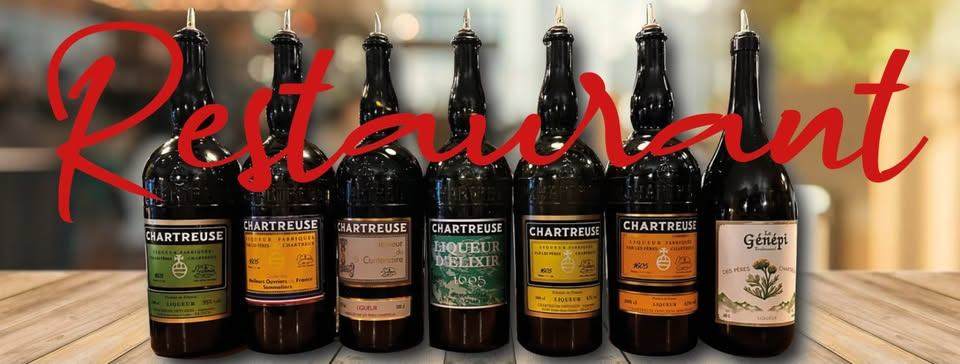 Collection de bouteilles de Chartreuse et de génépi alignées sur le comptoir du Bouchon de la Cave