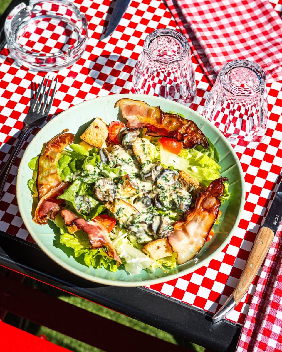 Salade au chèvre chaud et lard grillé sur nappe à carreaux