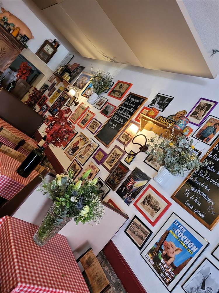 La salle du Bouchon, murs couverts de cadres et nappes à carreaux